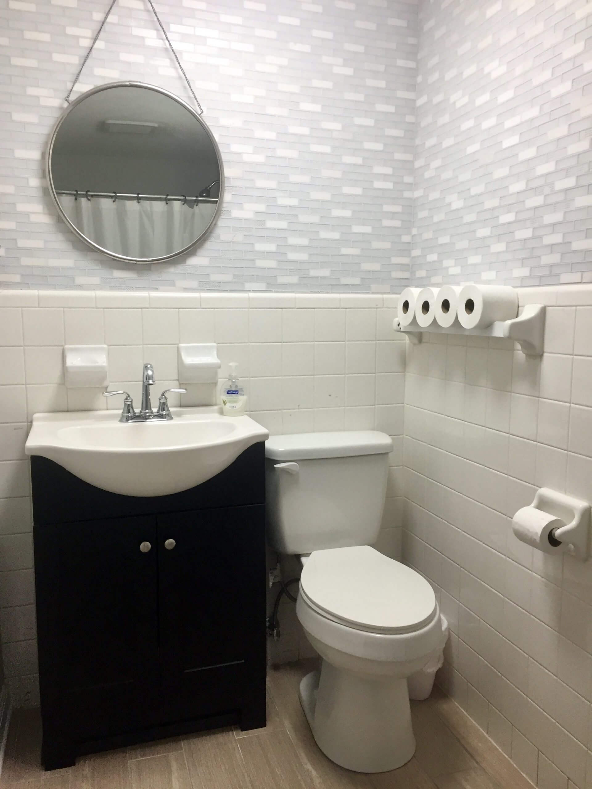 Bathroom remodel with mosaic wall tile, plank tile flooring, and a freestanding sink vanity